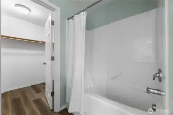 Primary bathroom with tub and walk-in closet
