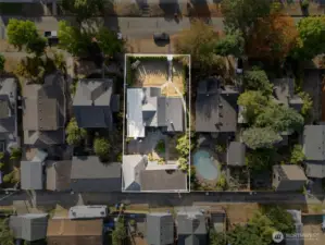 Aerial view of the property showcasing the fully fenced yard, lush landscaping, detached shop, covered carport, and overall lot layout in the desirable Edison District.