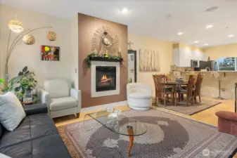 Open living with high ceiling, gas fireplace, dining, and breakfast bar. Built-in ceiling speakers throughout.