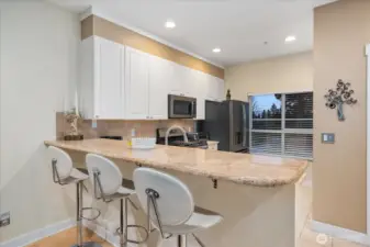 Bright kitchen with granite breakfast bar.