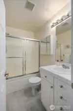 Bright primary en-suite bath with glass shower door.