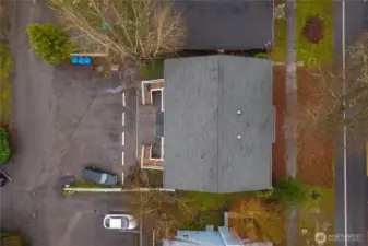 Aerial view of the clean roof and parking area in back.