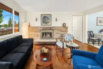 Inviting living room with original hardwoods and cozy wood burning fireplace