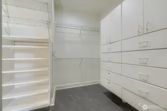 Walk-in closet with custom closet drawers and fxtures.