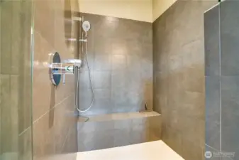 A generous walk-in shower with a built-in bench completes this spa-inspired space.