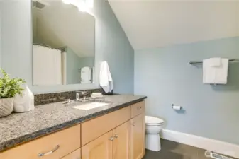 A bright and roomy full bath with ample counter space and plenty of storage. Quartz counters and tile floors add durability and a refined finish.