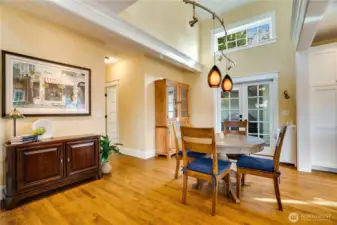 A soaring ceiling opens the dining room to the landing above, creating a bright, connected space. French doors open directly to the backyard, which includes a large private deck and the detached garage.