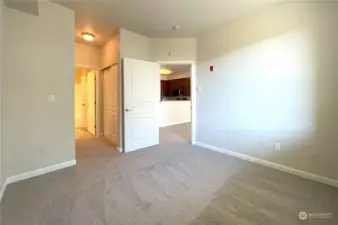 Another view of this spacious bedroom, showcasing its generous layout and ample closet space. The room seamlessly flows into the attached bathroom, creating the perfect retreat for comfort and convenience.