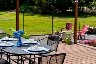 The large back patio offers plenty of room for family and friends to gather, dine, and relax. A covered sunshade provides comfortable shelter from the sun, making this outdoor space ideal for summer time entertaining, BBQs, and celebrations.