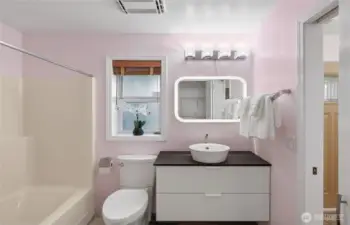 Contemporary lower level bath features updated fixtures, modern vanity, and tub for convenience.