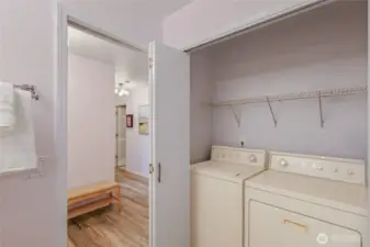 Lower floor laundry with built-in shelving and storage.