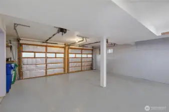 Spacious two-car garage features direct home access and workbench area.