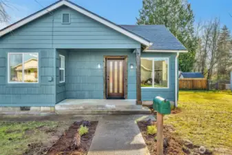 Nice front porch with a walkway to the gravel driveway that offers tons of extra parking!