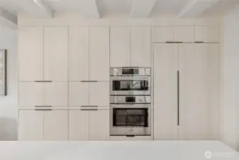 A wall of cabinets and a built-in refrigerator offer ample storage while maintaining a streamlined, modern look.