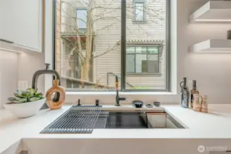 The oversized sink, equipped with a convenient cup washer, makes kitchen tasks a breeze.