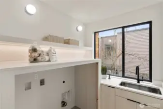 Bright Utility Space: The large laundry room features a utility sink and a generous window, providing ample light and functionality.