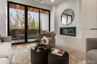 The large living area features a cozy fireplace and sliding glass doors that open to a spacious deck, perfect for seamless indoor-outdoor living.