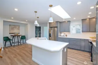 Huge island with Quartz Counters and plenty of seating - pretty pendant lights ensure a very bright eating area.
