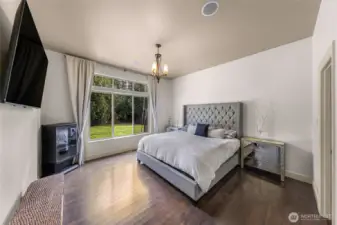 Spacious primary bedroom with large window and natural light