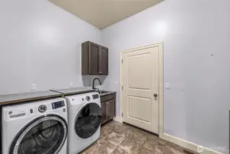 Laundry room with washer, dryer, and storage