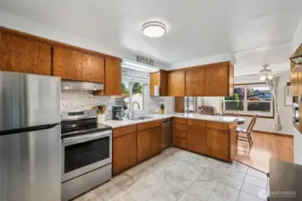 Stylish kitchen with updates- full tile backsplash, quartz countertops, stainless steel appliances, ceramic tile floors & nice window over looking the side yard with playground.