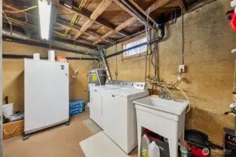 Unfinished part of the basement with laundry, deep sink & room for a freezer for extra storage needs.