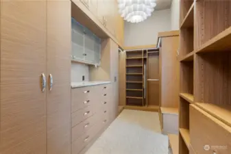 Primary closet with lots of shelving and cupboards