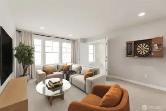 Large bonus room perfect for game, media, or playroom. Features French double doors and large windows for natural light. Photo contains virtual staging.
