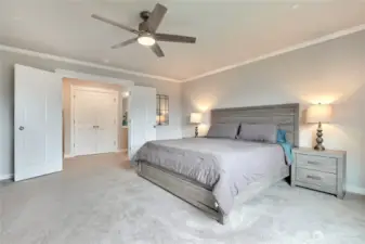 Spacious primary bedroom with french doors and a ceiling fan.