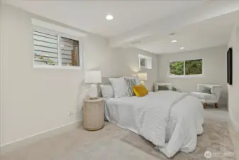 Massive primary bedroom with new can lighting and ample space for a lounge area or nursery.