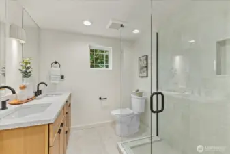 Primary bathroom with heated floors, glass shower, double vanities, and an abundance of light.
