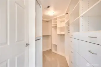 Ultra custom closet in primary with drawers, shelves, and hanging space.