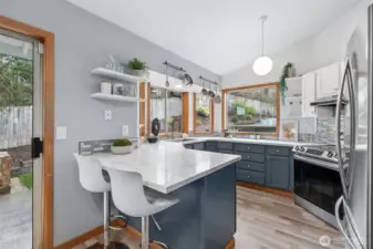 Updated kitchen with quartz countertops and tile backsplash.