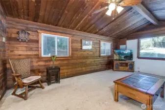 Living room has vaulted ceiling and a ceiling fan