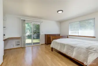 Bright primary bedroom has slider to the back porch