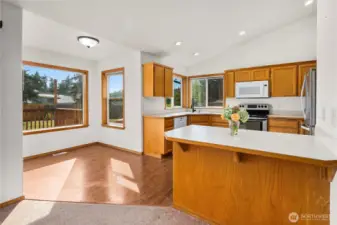 Vaulted ceiling in kitchen as well with eating bar.