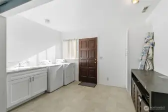 Large laundry area with sink and storage cabinets