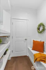 Great space leading to garage - storage/sit bench with storage shelves helps keep the home super organized!