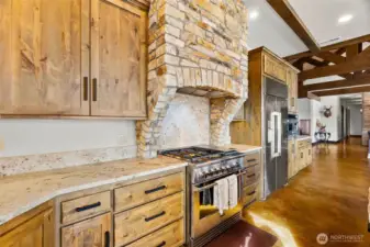 Chefs kitchen appointments. Propane range under the rock appointed stainless exhaust hood.