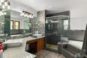 Primary Suite bath features double sinks, granite counters, a corner soaking tub, & gorgeous large tiled shower.