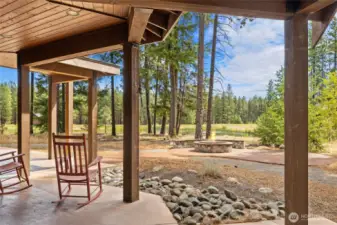 Outdoor covered space that stretches into more patio space with firepit