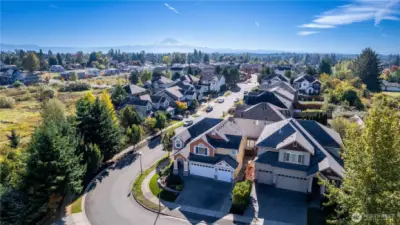 Take in the stunning aerial view of this peaceful East Hill neighborhood in Kent. From above, you can see the quiet, tree-lined streets, Mount Rainier in the distance, and well-kept homes that make this community so desirable. This corner-lot home enjoys the feeling of a cul-de-sac with minimal traffic—perfect for peaceful living close to parks, schools, and local conveniences.