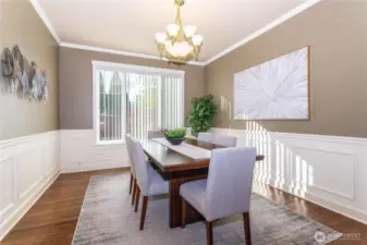 The formal dining room is a showpiece, featuring elegant wall molding, large picture windows, and a chandelier that adds warmth and charm. Whether it’s holiday dinners or everyday meals, this space feels both refined and comfortable. The light pours in during the day, creating a bright, welcoming atmosphere that anchors the heart of the home.