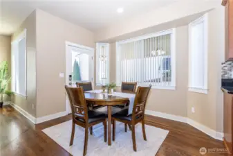 Sunny breakfast nook surrounded by windows with backyard views. Offers a comfortable space for casual dining and direct access to the patio through the sliding door.