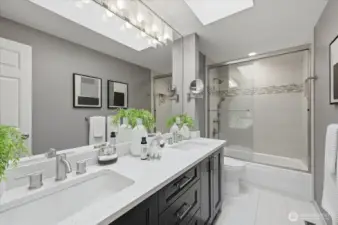 Completely updated hall bath; Heated tile flooring, double undermount sinks/vanity, tiled bath/shower with double head shower & valve, skylight & updated lighting!  No stone was left unturned here!