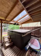 Covered patio with skylights and hot tub.