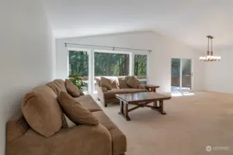 Main floor living room has high ceilings, gas fireplace and great light from the wall of windows.