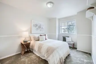 Sweet second bedroom on upper floor with shelving and large closet.