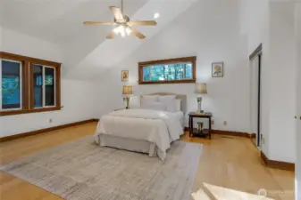 Primary Bedroom Upstairs with vaulted ceilings and fan.