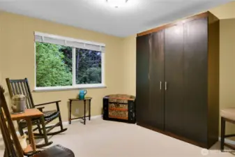 West bedroom with neutral carpet. Window with screen, looking out to the woods behind. Closet with paneled bi-fold Quaker doors. NOTE: Murphy Bed stays with home.
